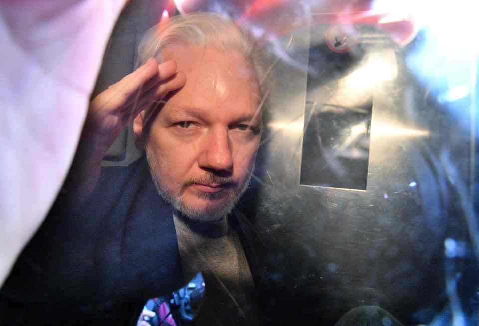  Assange gestures from the window of a prison van as he is driven out of Southwark Crown Court earlier this month