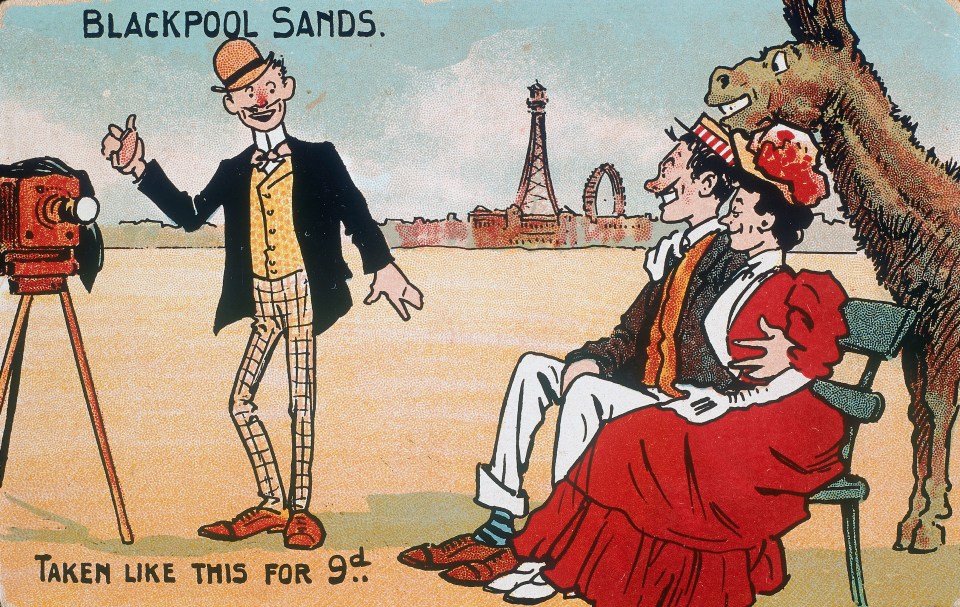  Postcard showing a comic photographer taking a group portrait on Blackpool beach. The couple being photographed, and a donkey, all smile for the camera