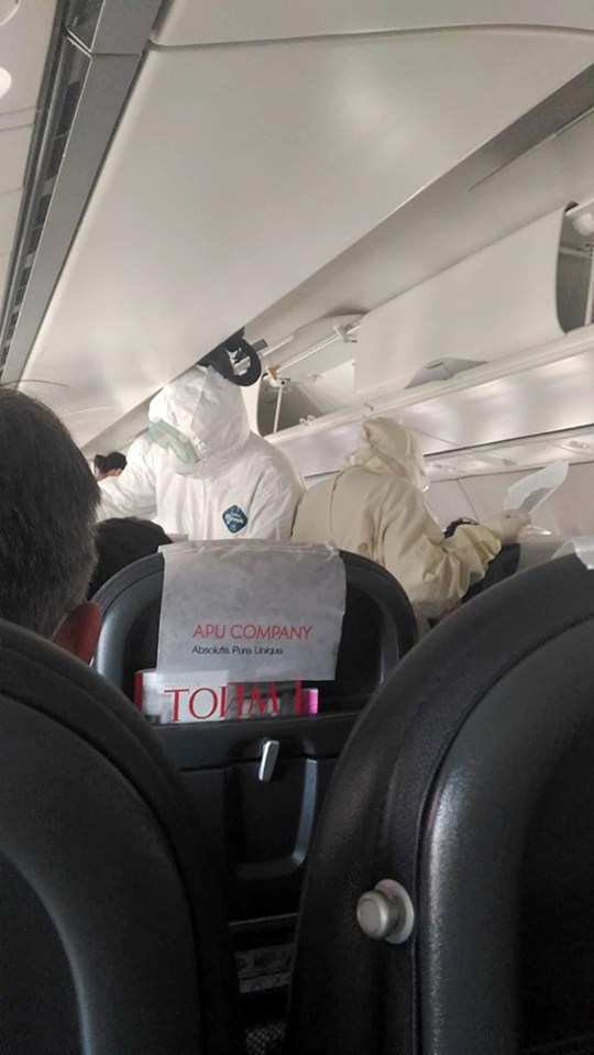  Medics dressed in anti-contamination suits removed 11 passengers from the plane