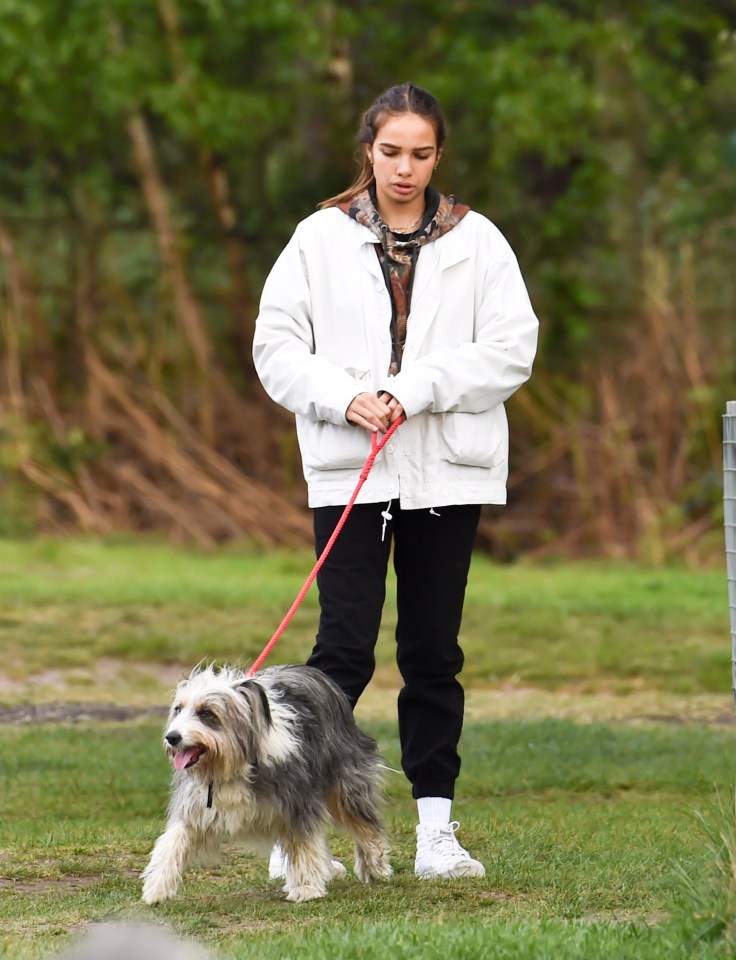  Hana looked effortlessly glam in her white coat as they walked a dog