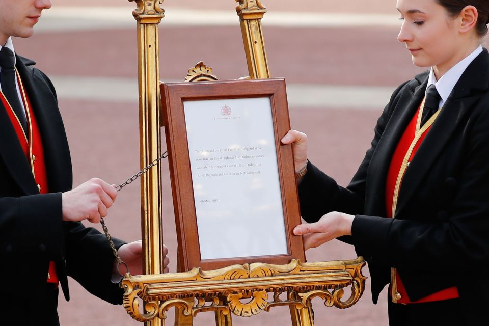  Members of staff set up an official notice on an easel at the gates of Buckingham Palace