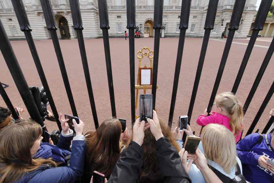  Crowds take a picture of the easel announcing Baby Sussex's birth