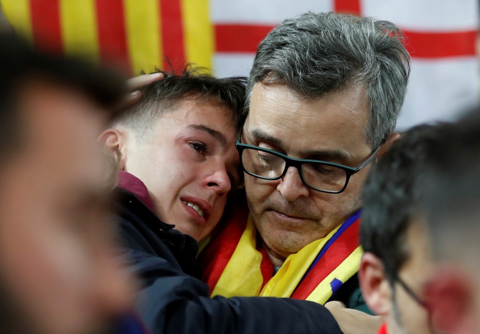  While a Barcelona fans comfort each other after their club crumbled at Anfield