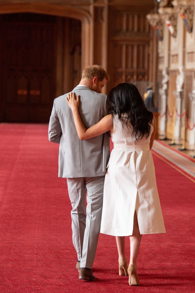  Mum Meghan puts a protective arm around her 'two guys'