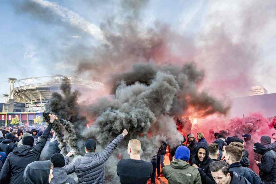  Ajax fans let off flares outside their stadium before kick-off