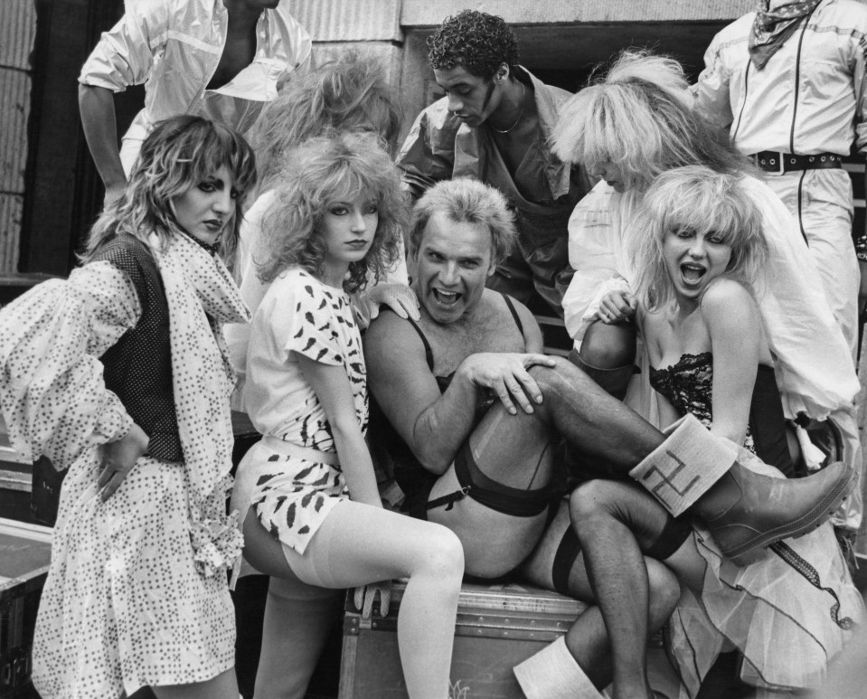  Freddie Starr poses in suspenders with British dance troupe Hot Gossip in 1981