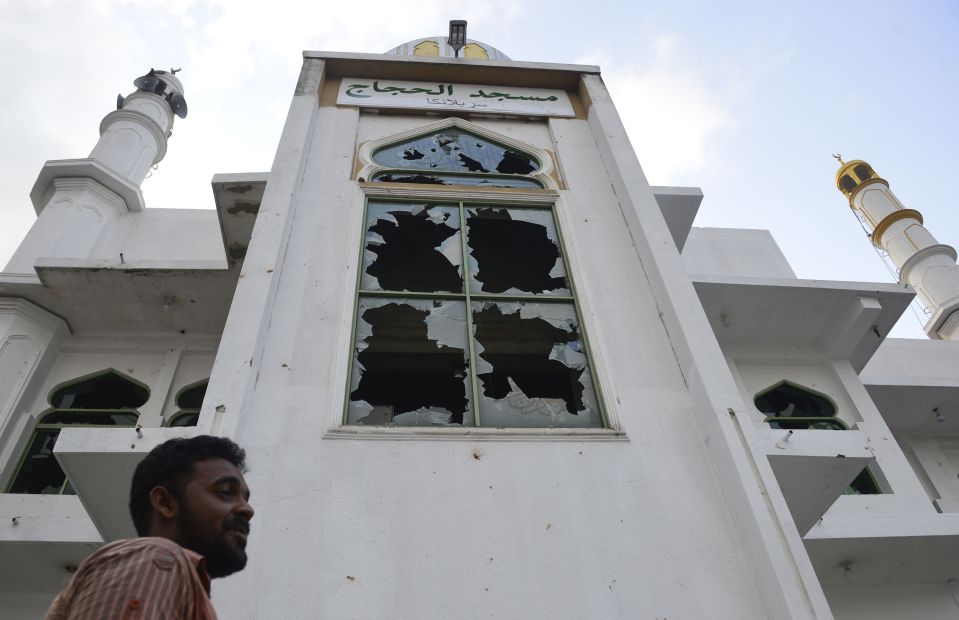  A Muslim man stands in front of the Jumha mosque after a mob attack