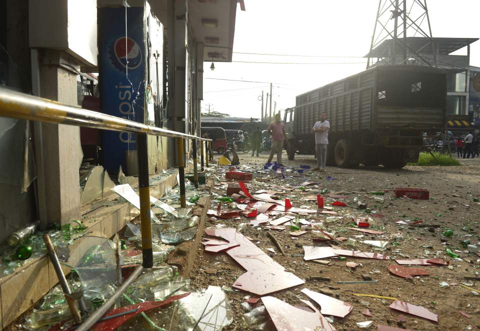  Debris of a business attacked by a mob is strewn on the road outside