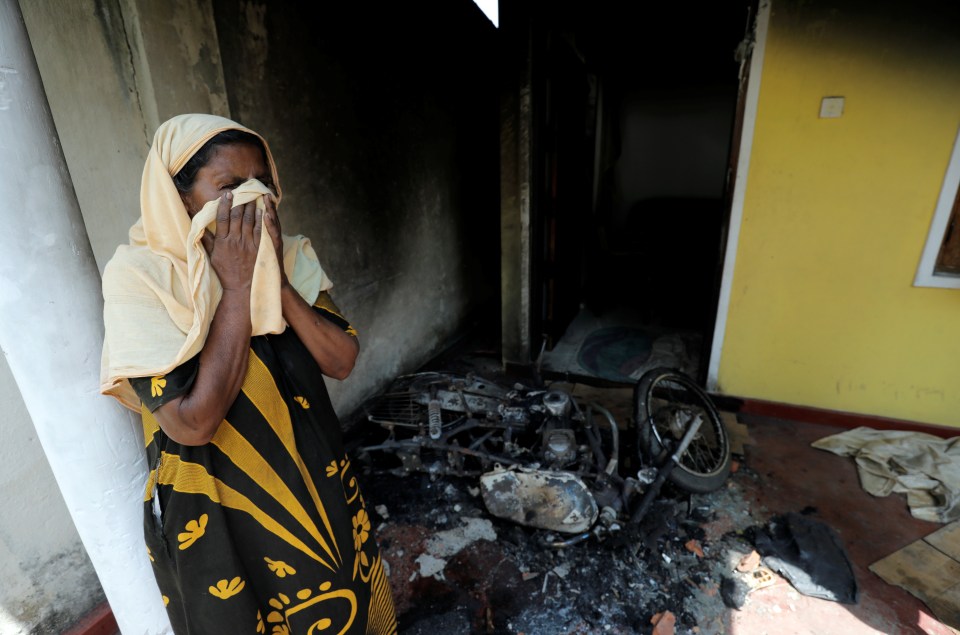  A woman sobbing in the burnt out remains of her home