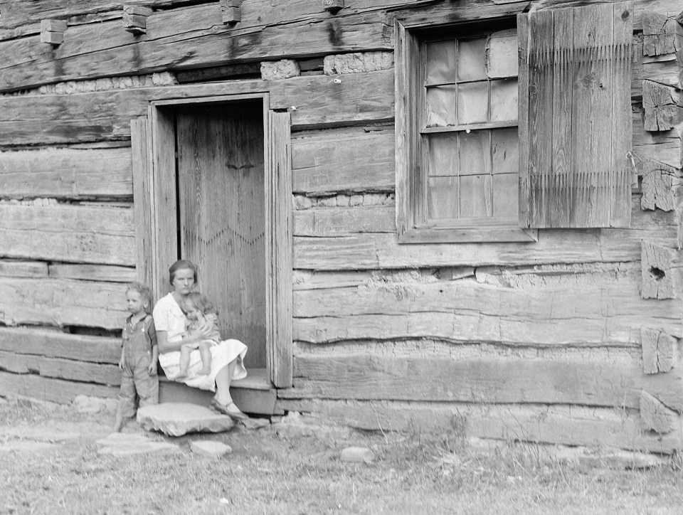 This 100-year-old cabin looks in need of repair as a desperate mother hugs her child closely