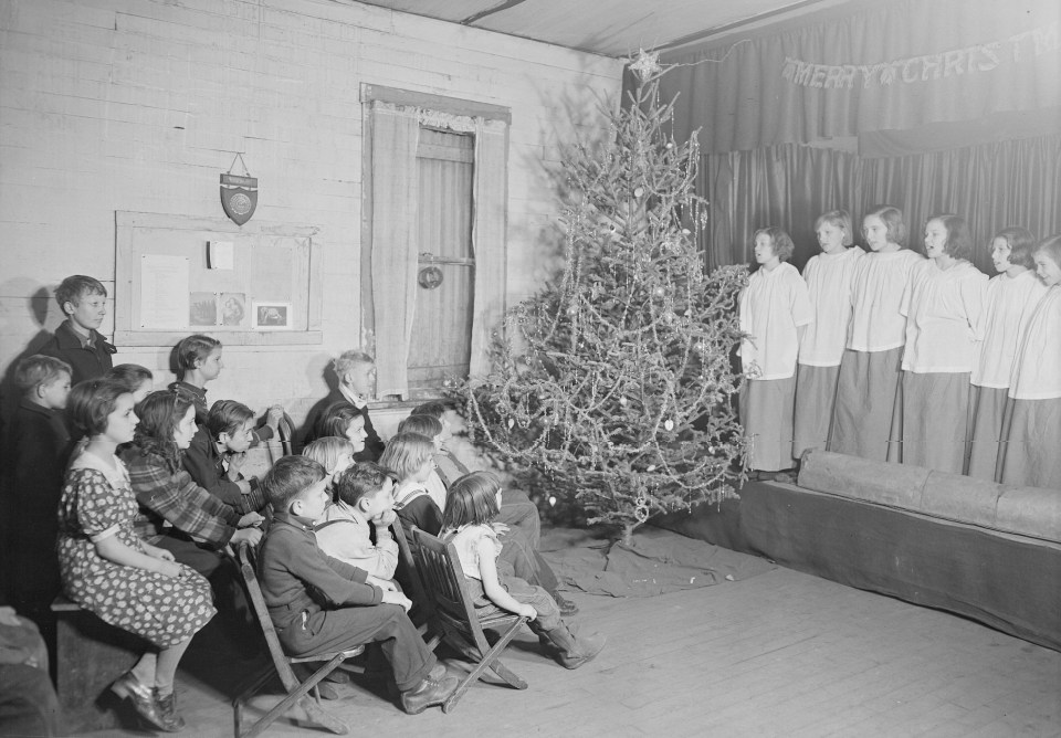 It promises to be a bare Christmas but this community enjoys a carol in 1937