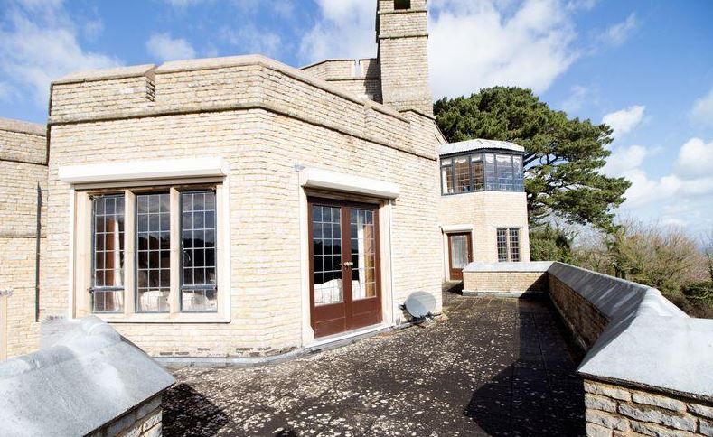 Double doors open out onto a private sun terrace with a view out to sea