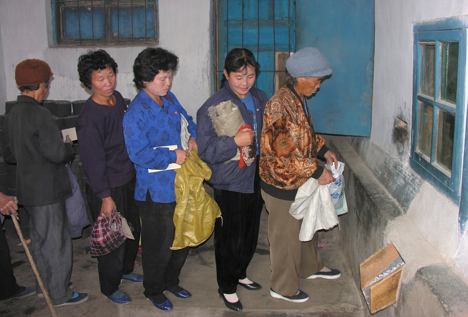  North Korean women queue to receive corn at a public distribution centre in 2005