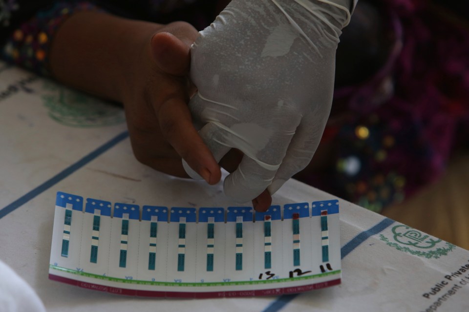  A doctor takes a blood sample of a villager to screen for HIV at a hospital near Ratodero, Pakistan