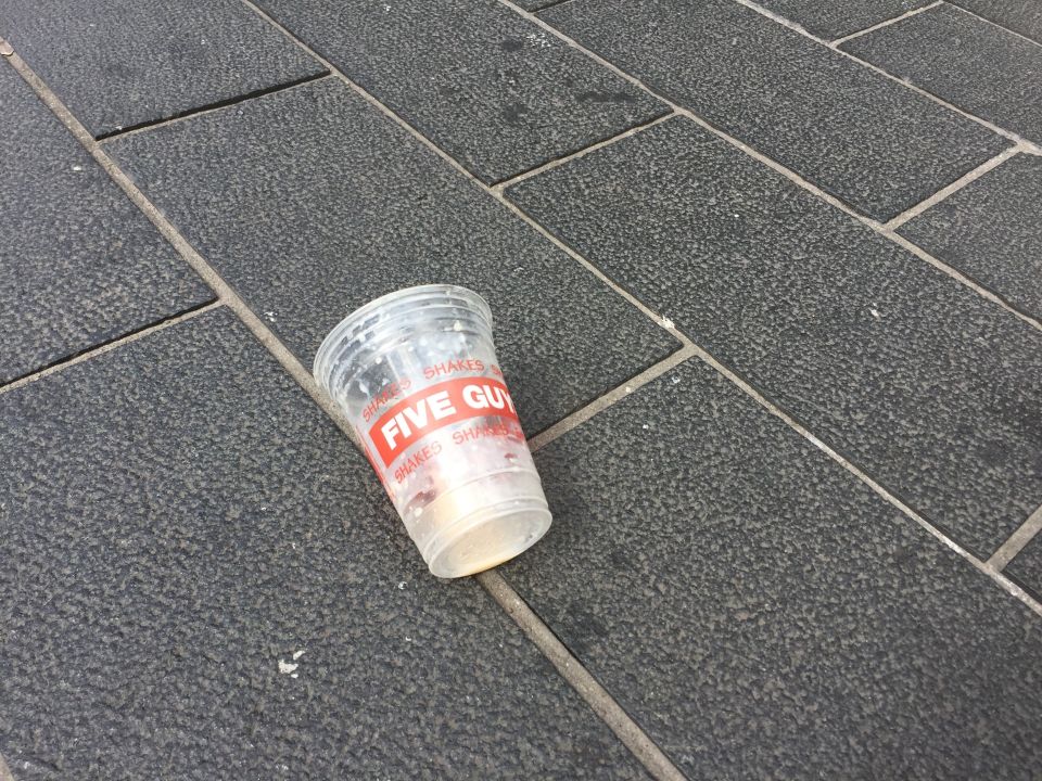  An empty milkshake cup lays on the ground - believed to be the one used in the attack