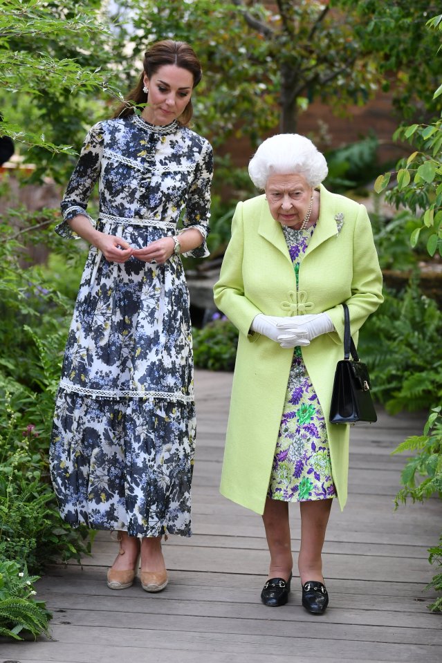  The royal pair, in complementing floral outfits, chatted as they walked through the garden displays