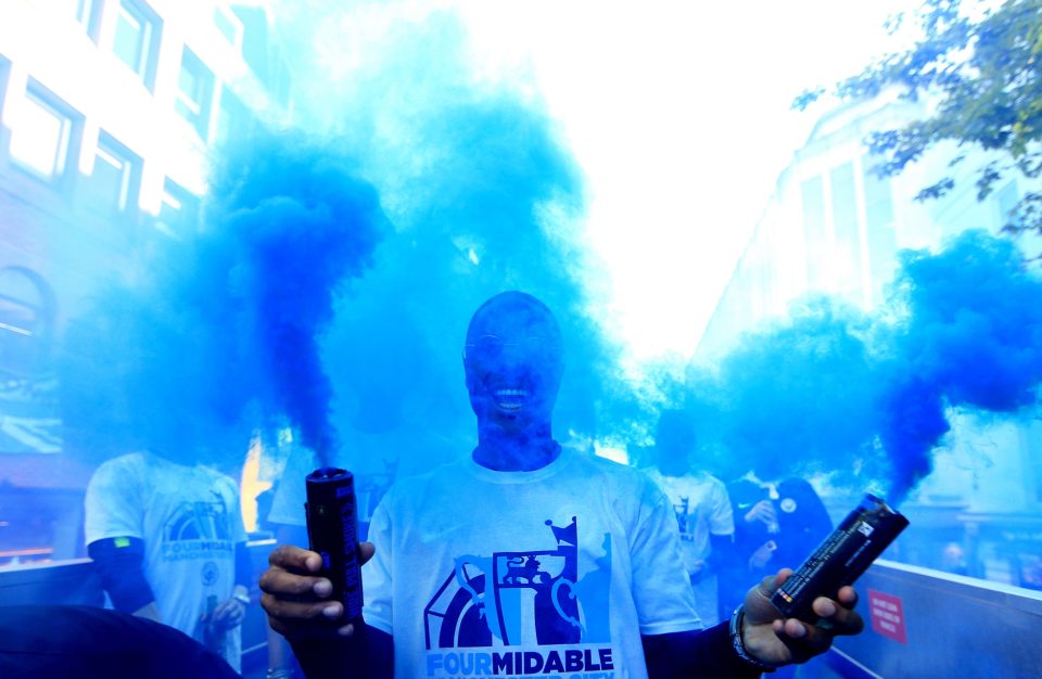  Raheem Sterling carries a blue smoke flare during the parade