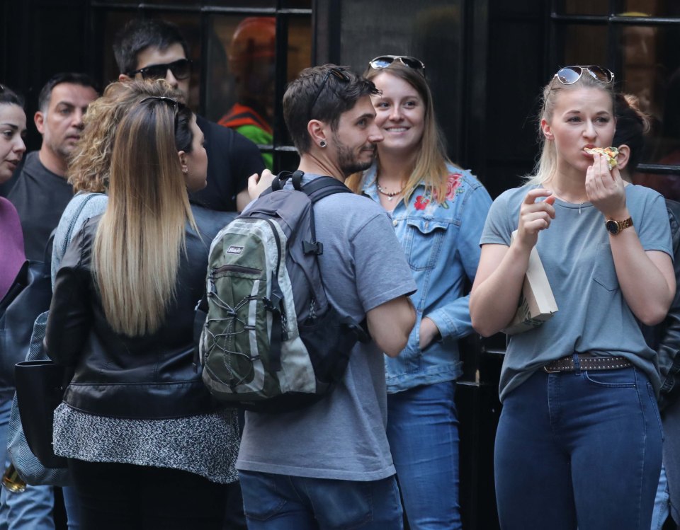  Staff were seen eating pizza as they waited for news outside one of the restaurants in Piccadilly, London