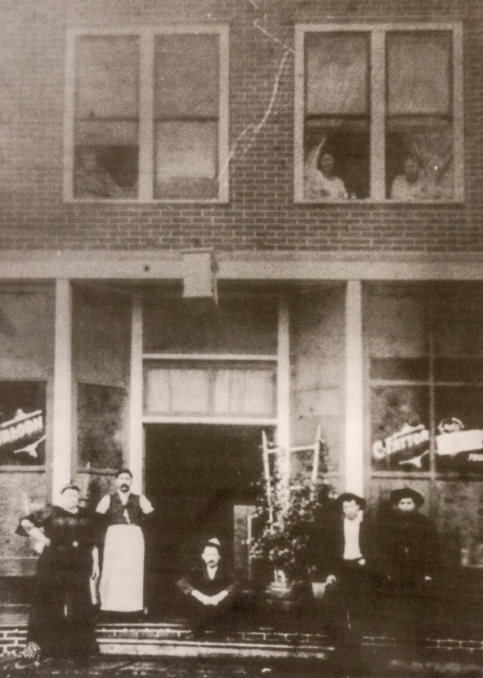  The Tremont on Blair Street in the mining town of Silverton in the San Juan mountains. Offering a combination of a saloon and a brothel, there was booze available downstairs and women working upstairs. The madam, pioneer prostitute Matilda 'Big Tilly' Fattor, is shown bottom left with her husband Celeste in the apron next to her, 1893