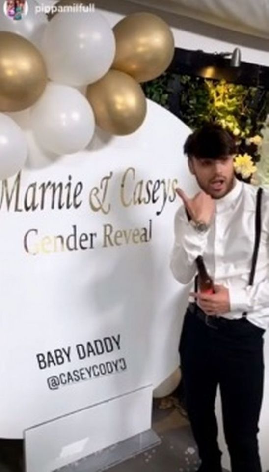  Casey posing next to a sign at the glitzy Gender Reveal party