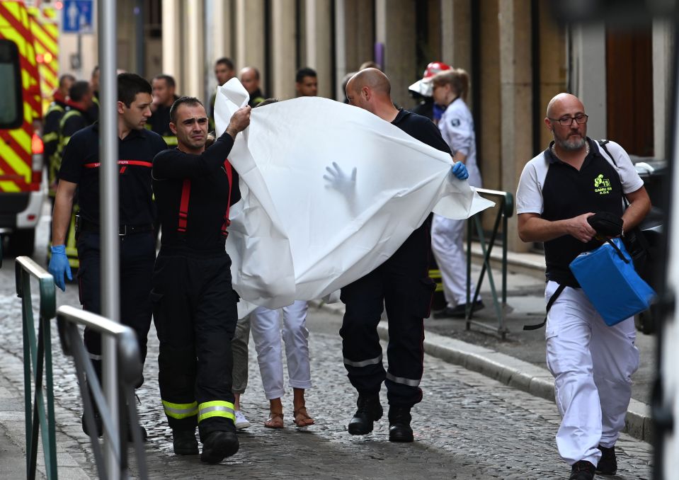  Emergency workers carry a victim in a blanket following the bomb attack