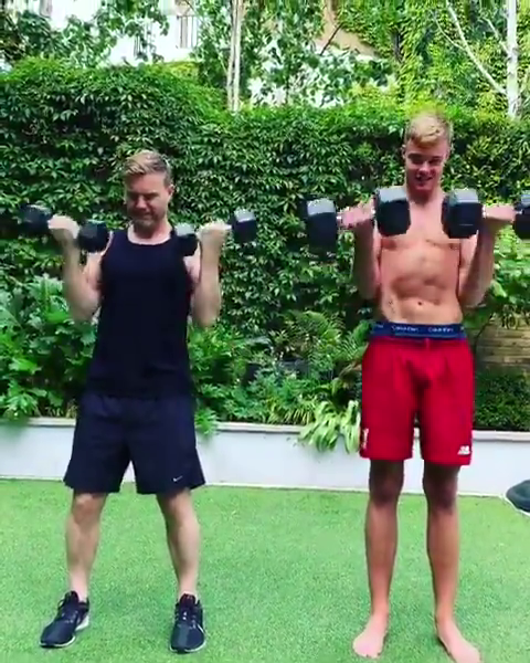 Take That star Gary and his son lifting weights in the garden