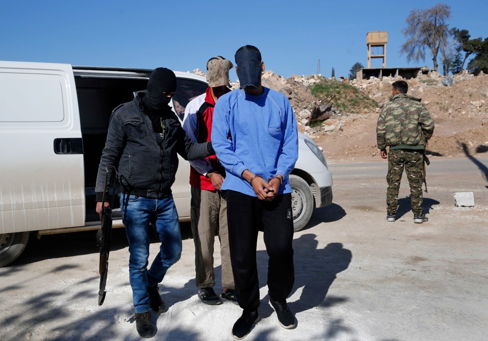  Kotey, foreground, and El Shafee Elsheikh are escorted from a van by Kurdish security forces