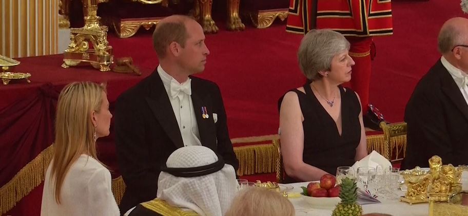 Prince William pictured sat next to Theresa May, who is wearing a plunging black gown for the occasion, and Suzanne Ircha, wife of the ambassador Woody Johnson