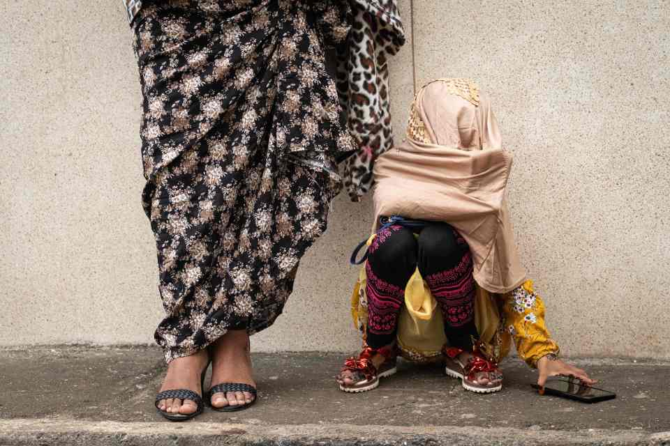 A Muslim girl picks up a mobile phone after attending Eid al-Fitr prayers at the Jamia Mosque in Nairobi, Kenya