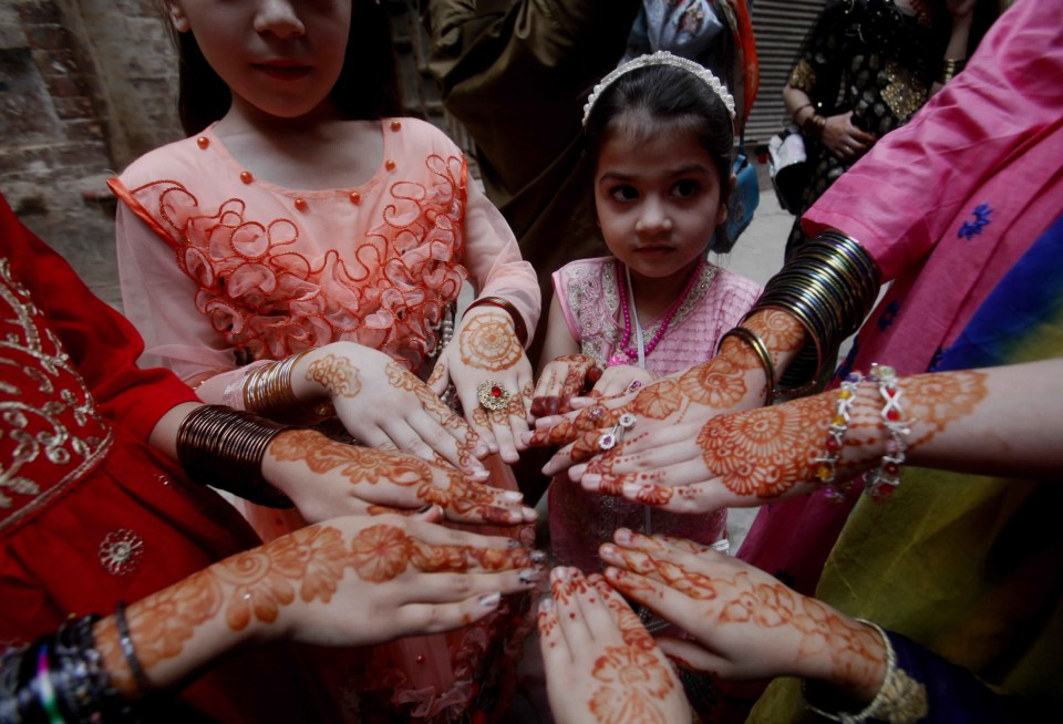 Muslims girls show their hands painted with henna at a Mosque in Peshawar, Pakistan