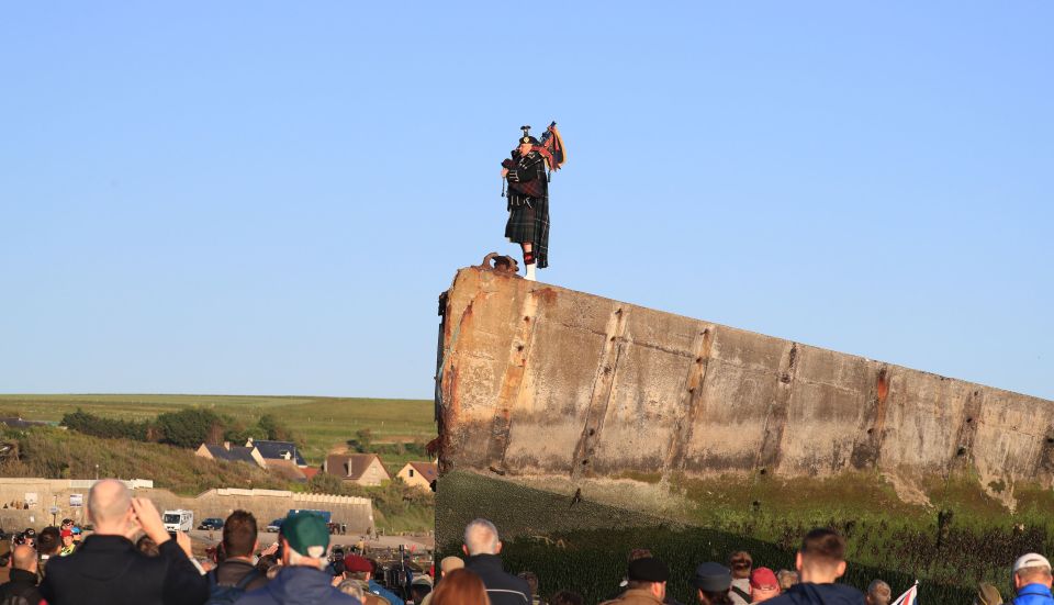  A lone piper plays on the Mulberry harbour at Arromanches in Normandy, in northern France, as British Army personnel mark the exact moment the first British soldier landed on Gold Beach 75 years ago