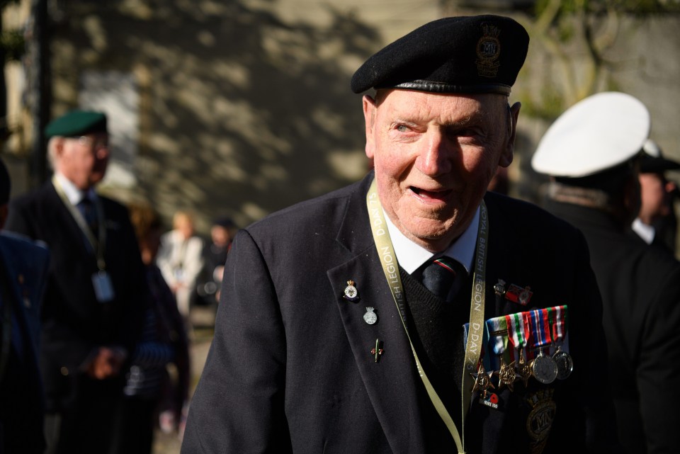 Veteran Tony Cash talks with pals outside the service of remembrance at Bayeux Cathedral