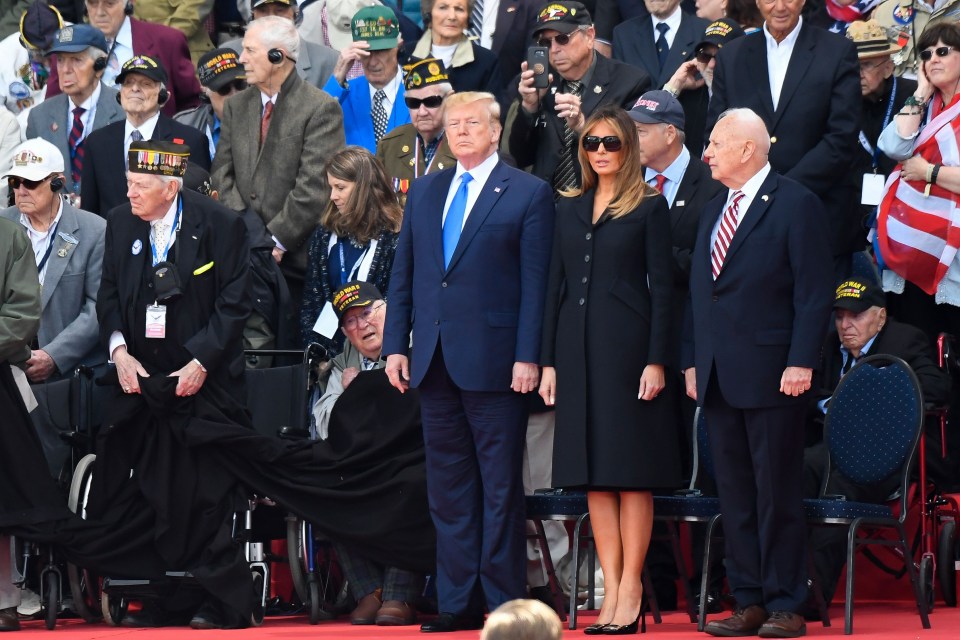 US President Donald Trump and First Lady Melania Trump stand with WWII veterans during a French-US ceremony at the Normandy American Cemetery and Memorial in Colleville-sur-Mer, Normandy