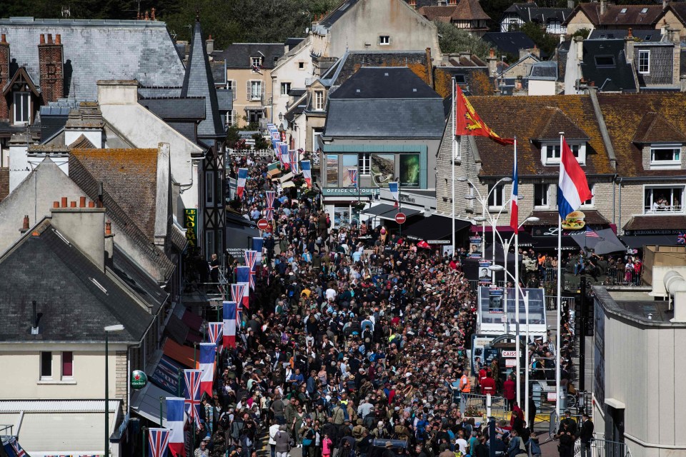 Visitors flood a street of Arromanches in Normandy for the commemorative events today