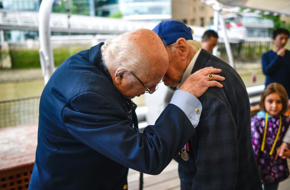 War veteran Ronald Yardley embraces D-Day hero Bob Jones on board HMS Belfast today