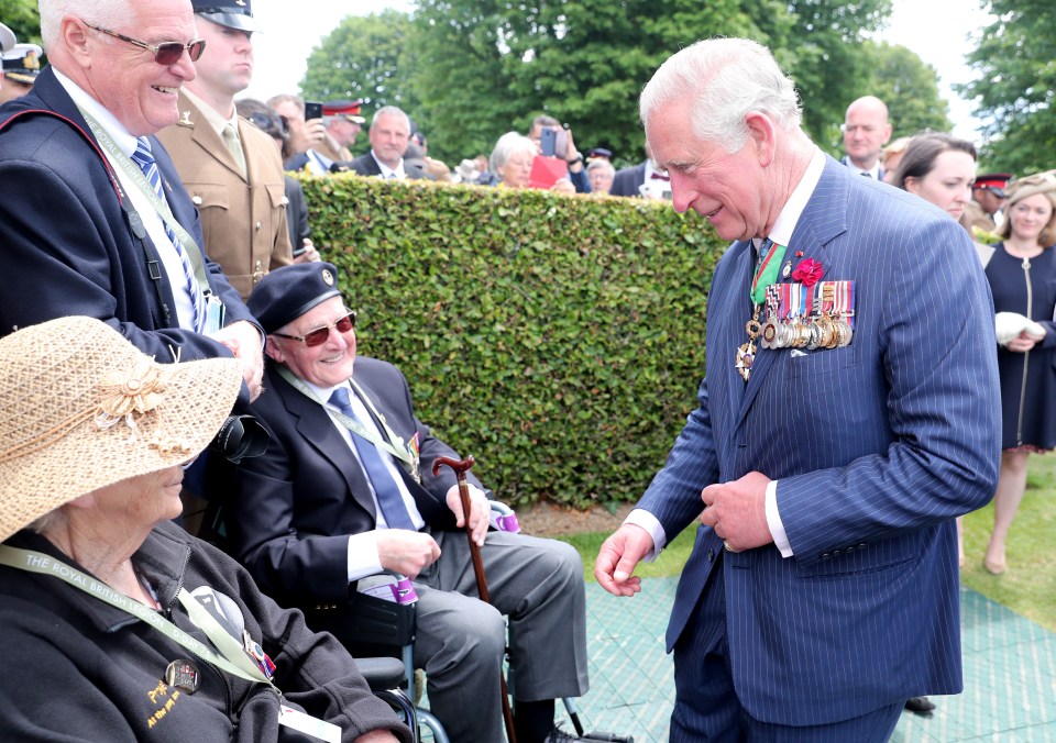 Prince Charles smiles as he meets with veterans at the Bayeux War cemetery 