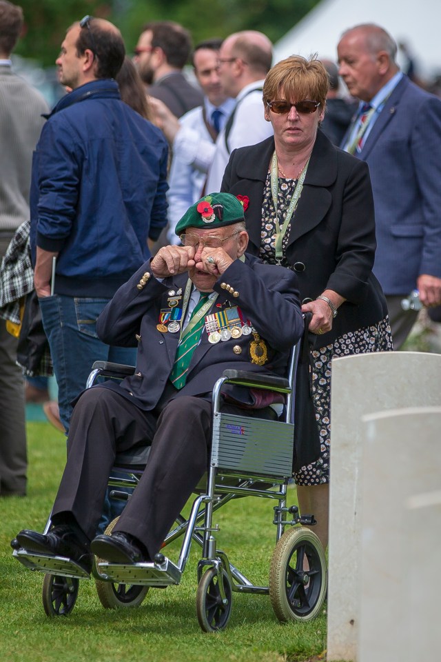 A veteran cries as he passes the headstones of the Bayeux Cemetery