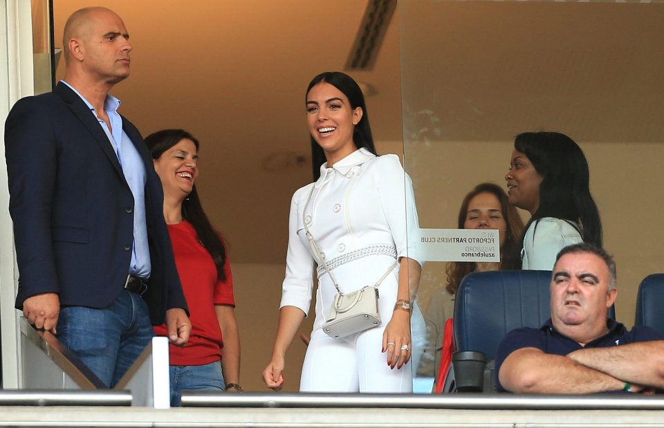  Georgina was dressed in a white jumpsuit with a matching leather handbag, had a huge grin on her face as her footy fella led out his nation for kick-off