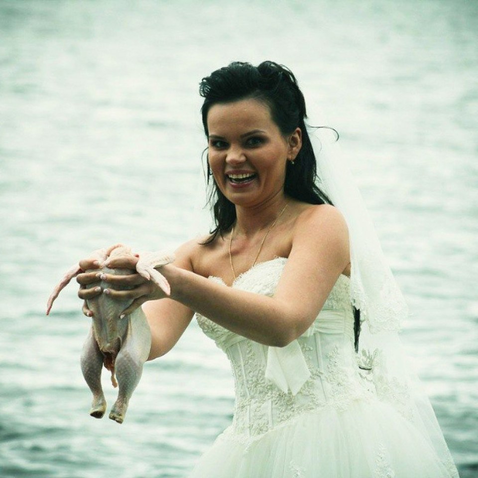 This bride is proudly holding her raw, featherless chicken for no apparent reason