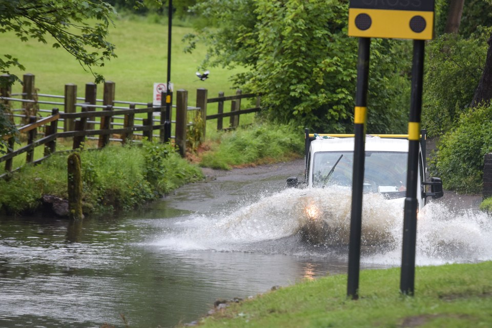 A van drives through flood water after torrential rain hit Birmingham today