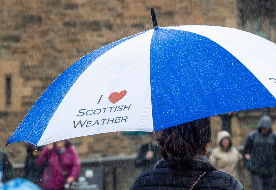 Edinburgh Castle visitors take on the wet weather after the country was hit by rain today