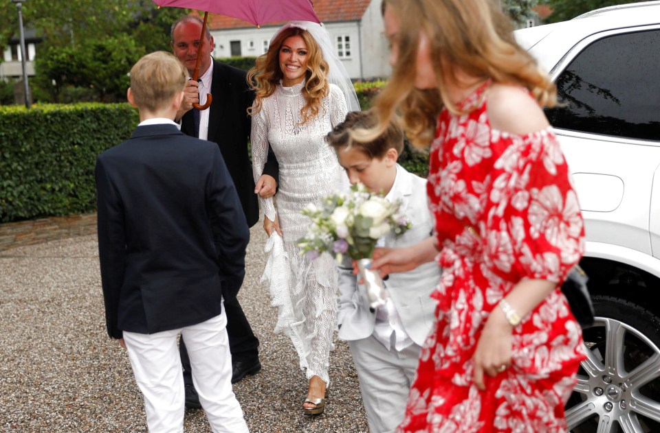  Laura wore a white dress as former keeper Schmeichel wore a navy suit