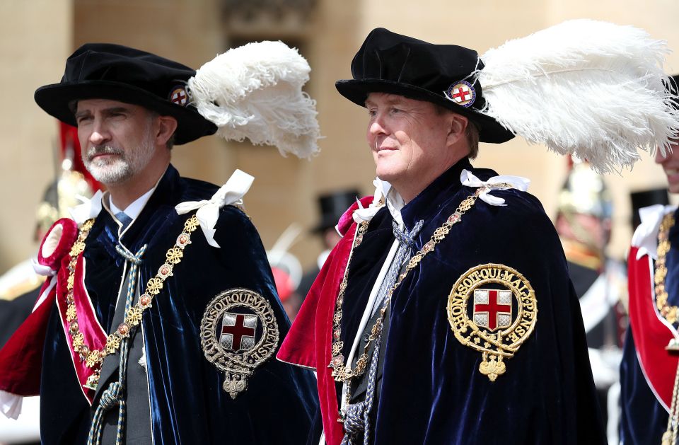  King Felipe VI of Spain (left) and King Willem-Alexander of the Netherlands walk together in their robes outside St George's Chapel