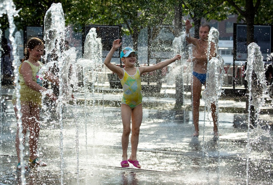  People cool off in a public fountain as temperatures reached 30C, in Moscow, Russia, Saturday