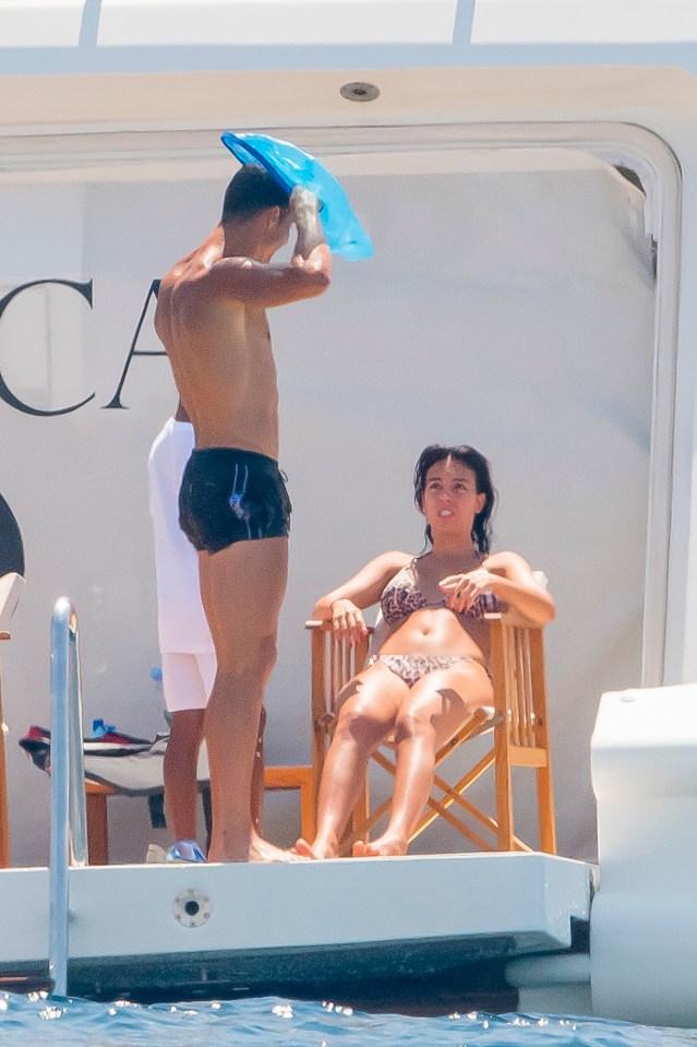 Ronaldo picks up a fishing net as he chats with Rodriguez on the back of the giant vessel