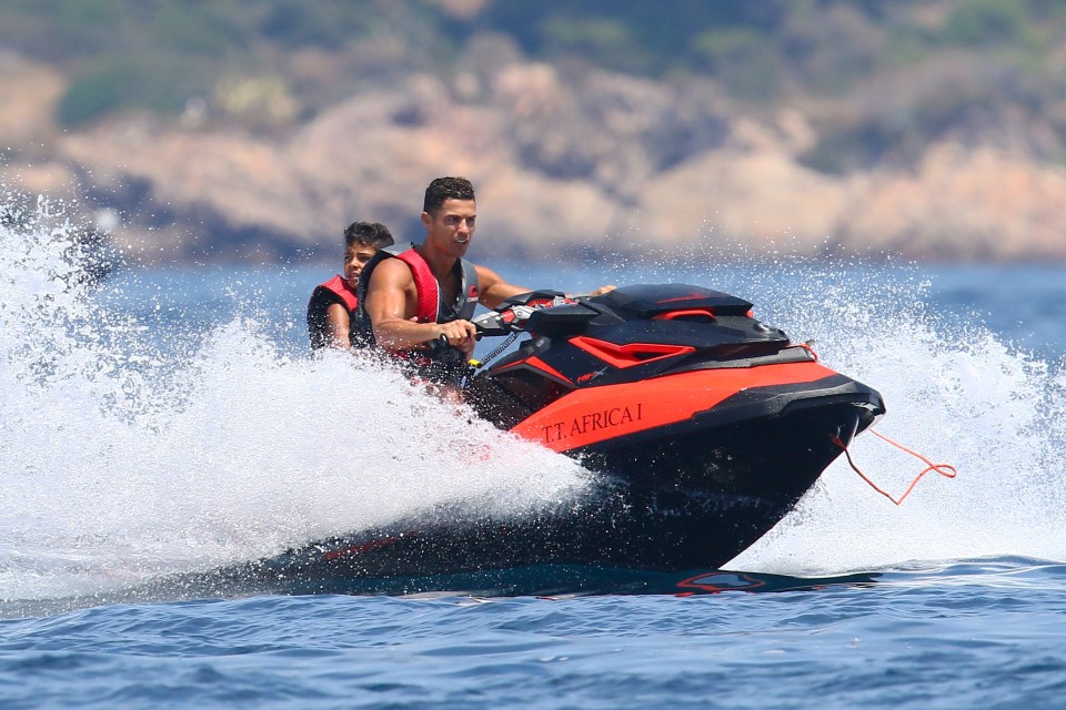 Cristiano Jr hangs on to his dad as they tear across the surf