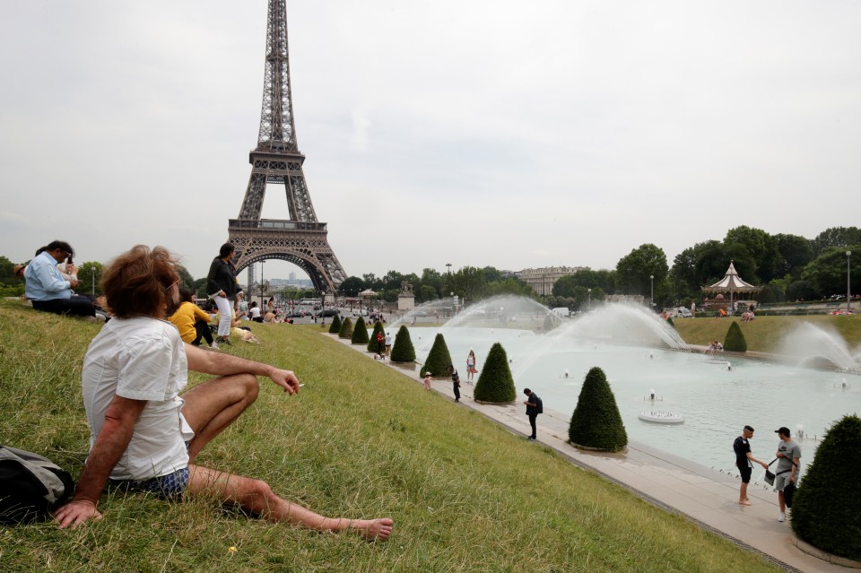  People sunbathe near the Trocadero fountains and the Eiffel Tower in Paris as a heatwave is expected in much of the country