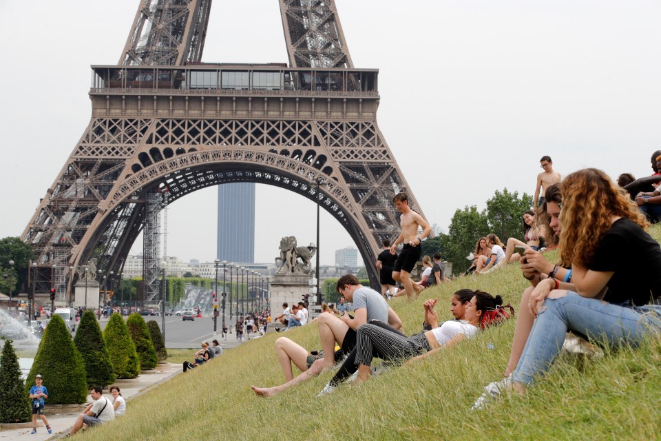  People sunbathe near the Trocadero fountains and the Eiffel tower in Paris as a heatwave is expected in much of the country