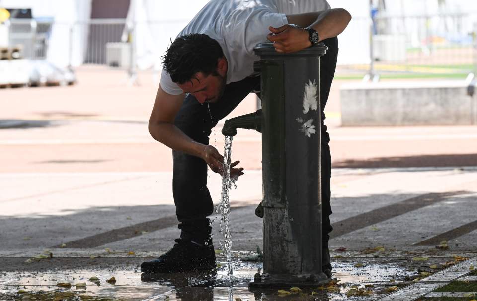  A man cools off at a water fountain in the French eastern city of Lyon on June 24