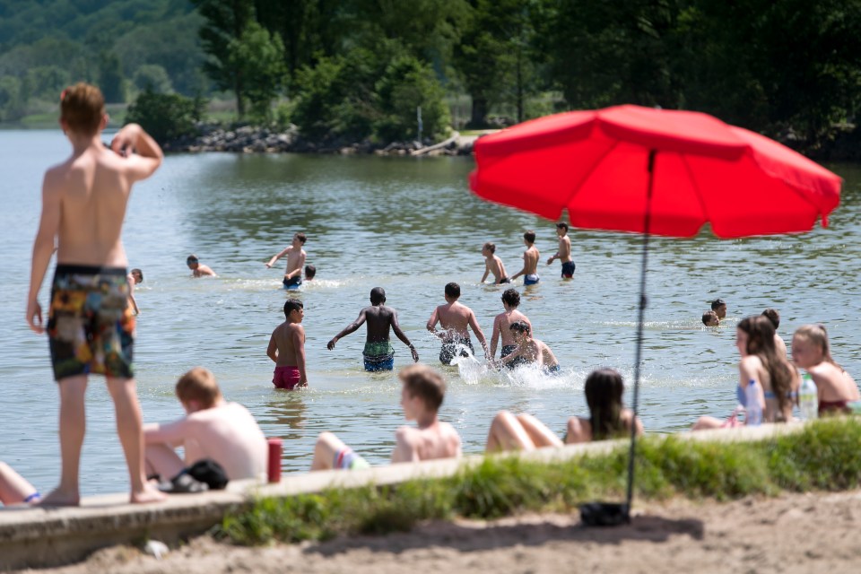  Children play in the water of the Lac de Neuchatel to cool off during the sunny and warm weather, in Yverdon-les-Bains, Switzerland